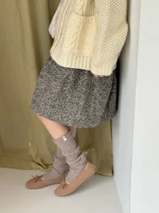 Detail shot of cozy knitted slouchy leg warmers, soft texture for winter warmth and daily styling.
