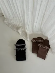 Close-up detail of women mid-calf socks with cute floral ruffles and ribbed knit texture.