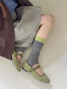 Close-up detail of striped footless socks worn with vintage flat shoes, soft texture fabric.