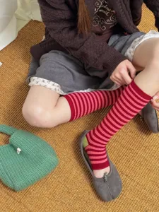 Retro striped stirrup socks for women, fashionable cotton long leg warmers for daily wear.