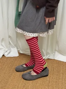 Detail shot of women's striped stirrup socks in pink and red with contrast heel design.