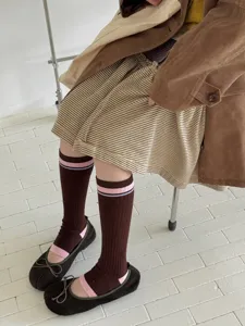 Detailed shot of retro contrast color striped high socks, cozy fall winter style.