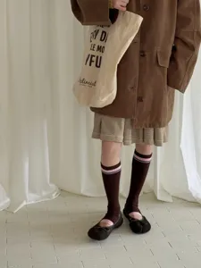 Detail shot of vintage contrast color striped knee-high socks paired with casual autumn outfit.
