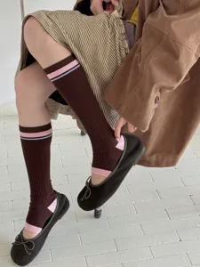 Retro striped stirrup socks for women, vintage contrast color long knit hosiery detail.