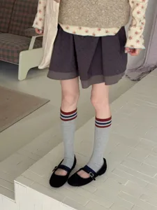 Detail view of retro color-block striped women socks paired with stylish black shoes.