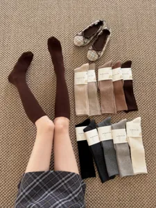 Ribbed knit long calf socks detail shot, soft warm solid color winter hosiery collection.