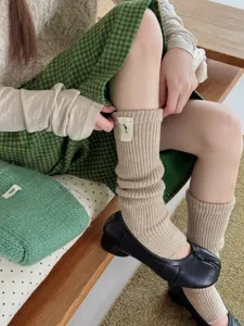 Detail shot of cozy beige knitted stirrup socks, showcasing soft texture and comfortable fit.
