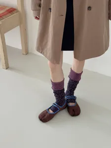 Detailed shot of Korean style colorblock striped layered socks and velvet split toe mary jane shoes.