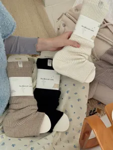 Detailed view of thick knitted leg warmer socks with paper packaging, cozy and warm style.