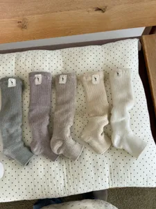 Knitted stirrup socks detail showing soft chunky texture and cute small logo tag on top.