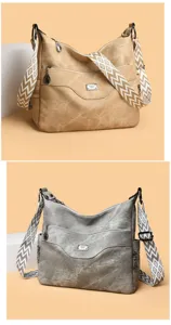 Women's soft leather crossbody shoulder bag with wide geometric strap and multiple zipper pockets.