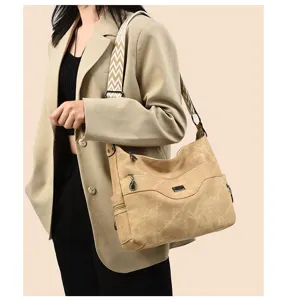 Detailed shot of a casual women shoulder bag with wide woven strap and large capacity.