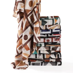 Detailed view of the geometric color block scarf showing fine fabric texture and neat stacking.