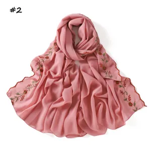 Bufanda de gasa rosa con delicado bordado floral y elegantes bordes festoneados.