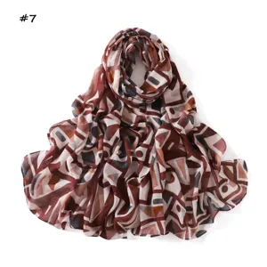 Geometric print detail of the soft cotton long scarf, showing intricate abstract pattern design.