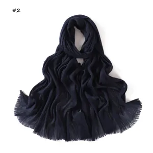 Close-up detail of the navy blue pleated scarf showing fine texture and fringed edge craftsmanship.
