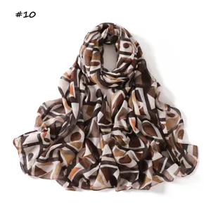Geometric print scarf detail, soft brown and white color block shawl, trendy abstract pattern.
