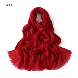 Detailed view of the solid red crinkled scarf with stylish fringe tassel edges.