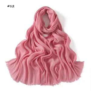 Pink pleated scarf detail showcasing delicate texture, lightweight breathable fabric and fringed edges.