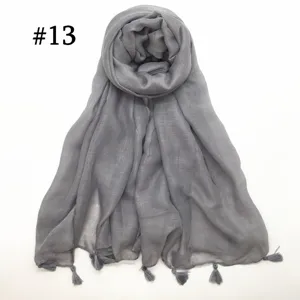 Close-up view of the lightweight gray voile scarf showing fine tassel hem and texture.