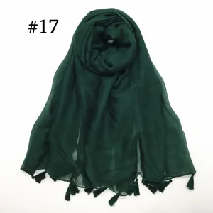 Green voile scarf detail showcasing tassel fringe, lightweight texture and fine weave.