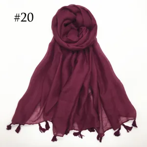 Detailed view of lightweight burgundy voile scarf featuring delicate hanging tassels and breathable fabric.