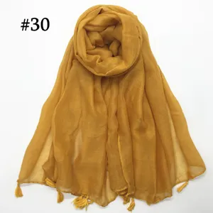 Detail view of mustard yellow voile scarf, lightweight breathable fabric with chic tassels.