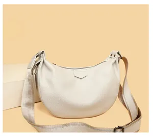 Casual dumpling crossbody bag in beige leather with wide strap and zip closure for women.