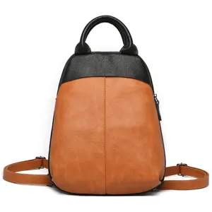 Leather two-tone backpack detail showing contrast color texture and top handle.