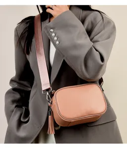 Detailed view of the elegant women's leather crossbody bag with a wide strap and tassel.