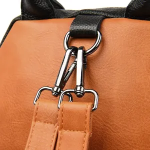 Close-up detail of the metal hardware and strap connection on the leather backpack.