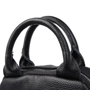 Black genuine leather backpack handle detail, fine texture, durable hardware zipper close up.