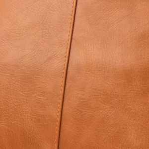 Close-up view of the fine brown leather texture and neat stitching details of the bag.