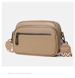 Vue détaillée du sac bandoulière en cuir marron avec double fermeture et bandoulière.