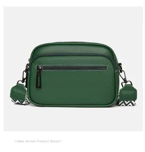 Sac bandoulière en cuir vert foncé avec une sangle large et une double fermeture.