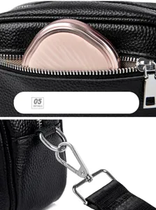 Black genuine leather crossbody bag detail, silver tone hardware and zipper, practical daily purse.