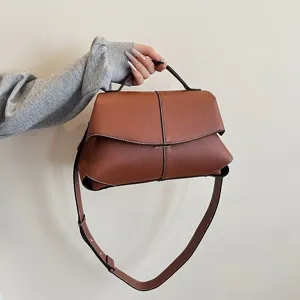 Sac à main en cuir marron pour femme, design géométrique élégant avec poignée et bandoulière.