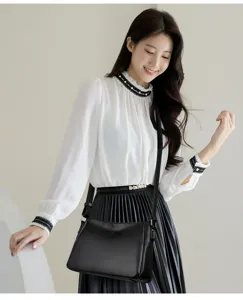 Detailed view of the black leather shoulder bag showcasing texture, strap, and hardware.