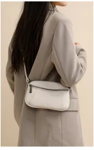 Detail view of a genuine leather women crossbody bag in white with double zipper and strap.