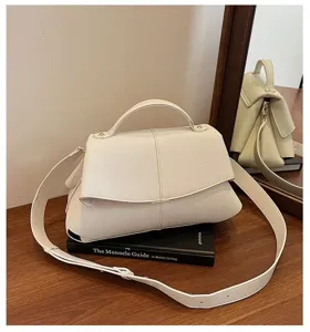 Vue détaillée du sac à main blanc porté épaule avec design plissé et sangle réglable.