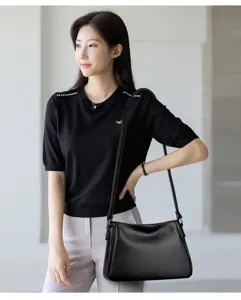 Detailed view of the black leather shoulder crossbody bag, highlighting soft texture and straps.