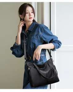 Detailed view of the black soft leather shoulder bag worn by model, large capacity design.