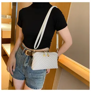 White quilted leather crossbody bag with chain hardware and adjustable shoulder strap for women.