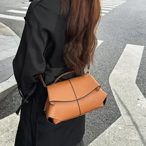 Sac bandoulière en cuir marron avec poignée supérieure et design à rabat élégant pour femmes.