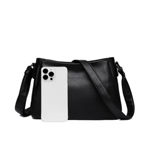 Detailed view of black leather shoulder bag, elegant pebble grain design with adjustable strap.