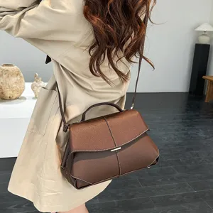 Sac à bandoulière en cuir marron pour femme, élégant sac Boston avec coutures contrastées.