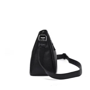 Side detail view of a minimalist black leather women's casual crossbody shoulder bag.