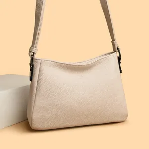 Detailed close-up view of the elegant beige leather shoulder bag with textured surface.