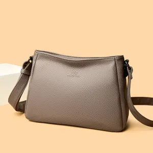 Grey women shoulder bag detail shot, simple crossbody PU leather bag with brand embossed.