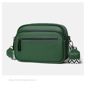 Vue détaillée du sac bandoulière pour homme en cuir vert foncé avec poche zippée texture.